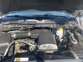 View of a 2021 RAM 1500 engine with a 3.6L V6 engine block and various components including hoses and a coolant reservoir
