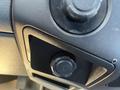 A close-up of a control panel in a 2015 Ford F-550 featuring a knob and a 12V power socket