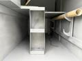 Interior view of a 2014 International TerraStar truck showing metal storage shelves and a pipe along the side