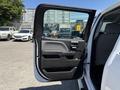 The open door of a 2016 GMC Sierra 1500 revealing a black and gray interior with a sleek handle and window controls