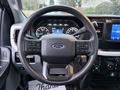 Steering wheel of a 2023 Ford F-250 with control buttons and the Ford logo in the center