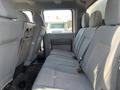 Interior view of the backseat of a 2015 Ford F-450 SD with gray fabric seating and seatbelts visible