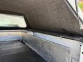 The interior of a 2014 Ford F-250 SD truck bed with a fitted cap and a sliding storage drawer along the side