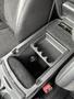 An open center console in a 2022 Dodge Charger featuring a compartment and a power outlet with four cup holders