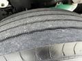 A close-up view of a worn tire from a 2012 Freightliner M2 106 showing visible tread patterns and texture