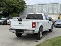 A white 2018 Ford F-150 truck viewed from the rear with a standard bed and 4x4 badge on the tailgate