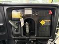 Dashboard of a 2016 International CE300 showing various controls and warning labels with a gear shift lever and keys hanging from a tag