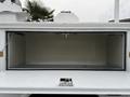 A 2001 Ford F-350 vehicle with an open storage compartment revealing a spacious interior devoid of items
