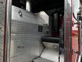 A 1991 Sutphen Deluge fire truck featuring metal diamond plate surfaces and a black leather seat adjacent to a control panel