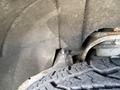 Close-up of the suspension components and tire of a 2014 GMC Sierra 1500 showing metal parts and tread pattern