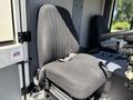 A black fabric operator seat of a 2001 Tennant 830-II with vertical ribbing and a seatbelt