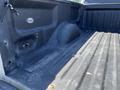 Interior of a 2014 Ford F-150 truck bed showing a textured surface and wheel well on the left side