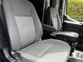 Two gray cloth seats from a 2022 Ford Transit van with patterned upholstery and armrests.