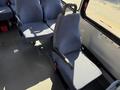 Interior of a 2017 Chevrolet Express showing a single passenger seat with a fabric cover and an armrest placed next to a row of other blue fabric seats