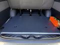 Interior of a 2023 Mercedes-Benz Sprinter showing a flat cargo area with seating storage and an orange tool box with cables on the side