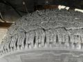 Close-up of a worn tire tread on a 2010 Ford F-250 SD highlighting cracks and grooves in the rubber indicating usage and wear