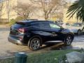 A 2021 Nissan Murano in black parked with its rear angled towards the viewer showcasing its sleek design and alloy wheels