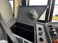 Open storage compartment of a 2013 International 4200 featuring a round cap and control knobs for various functions