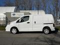 A white 2017 Nissan NV200 van is parked with its side profile visible featuring sliding doors and steel wheels