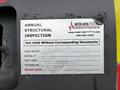 A metal inspection label attached to a 2009 Spartan Gladiator indicating annual structural inspection details and technician information