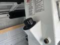 A close-up of a white control panel featuring a black knob and warning labels typically found in the back of a 2008 Ford Econoline van