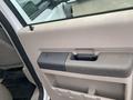 Interior door handle of a 2009 Ford F-450 SD with a beige panel and a darker section for gripping