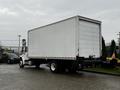 A 2018 Freightliner M2 106 box truck with a white cargo area and a clear panel at the rear