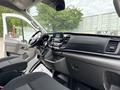 The interior of a 2023 Ford Transit featuring a modern dashboard with a touchscreen display and two front seats