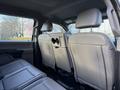 Interior view of the back seating area of a 2020 Ford F-550 showing two gray seats with headrests and a fold-down armrest in the center