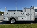 A 2004 Freightliner M2 truck with a white exterior featuring tool storage compartments and utility equipment mounted on the side