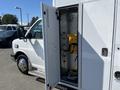 A 2016 Chevrolet Express van with an open side door revealing interior equipment and storage space