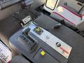 Interior view of a 1994 Volvo FE 42 showing the gear shift lever control panel with buttons and dials on the central console and a black and red seat nearby
