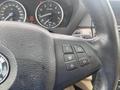 Close-up of the steering wheel of a 2009 BMW X5 showing control buttons and part of the dashboard with speedometer and warning lights