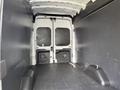 Interior of a 2021 Ford Transit van showing a spacious cargo area with a flat floor and two rear doors partially open