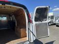 A 2012 Chevrolet Express cargo van with an open rear door revealing a wooden storage box inside the cargo area