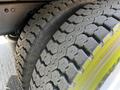Close-up of a heavily treaded tire from a 2012 Freightliner M2 112 with a rugged pattern for enhanced traction and durability