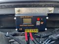 A solar power controller mounted inside a Mercedes-Benz Sprinter with a digital display and USB port
