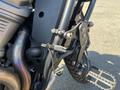 Close-up of a 2021 Harley-Davidson RA1250 S motorcycle showing the footpeg assembly and gear shift mechanism