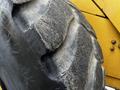 A close-up view of a large, worn tire from a 2006 John Deere 470G featuring deep treads and rugged surface texture