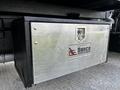 A silver storage box with a lock bearing the Danco Equipment Inc logo mounted on a black truck