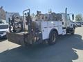 A 2007 International 7300 truck with a utility body featuring multiple reels and a rear-mounted work platform