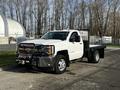 A 2017 Chevrolet Silverado 3500HD truck with a flatbed and front grille guard in white color