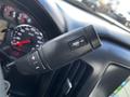 The image shows a close-up of the control stalk on the steering column of a 2017 GMC Sierra 1500 with buttons for settings and a speedometer in the background