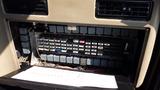A control panel with numerous gray and colored switches and fuses organized in a grid pattern with a schematic diagram laid out below