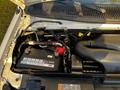 The engine compartment of a 2017 Ford Econoline showing the battery and various components including hoses and fluid reservoirs
