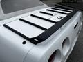 A 1992 Chevrolet Corvette with a distinctive rear wing and sleek design featuring round taillights and a smooth white finish