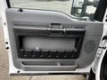 Interior door panel of a 2015 Ford F-550 featuring a handle and storage compartment