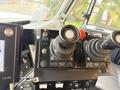 Control panel of a 2016 International 7600 featuring two joysticks and various buttons for controlling equipment