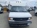 A white 2004 Ford Econoline van with a boxy design and a flat front featuring headlights and a grille