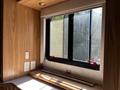 A 2000 Ford Motorhome interior with wooden panels and a window featuring red clips and a white exit sign on the sill